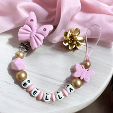 Lade das Bild in den Galerie-Viewer, Baby Schnullerkette personalisiert mit Namen Mädchen gold rosa Silikon Schmetterling